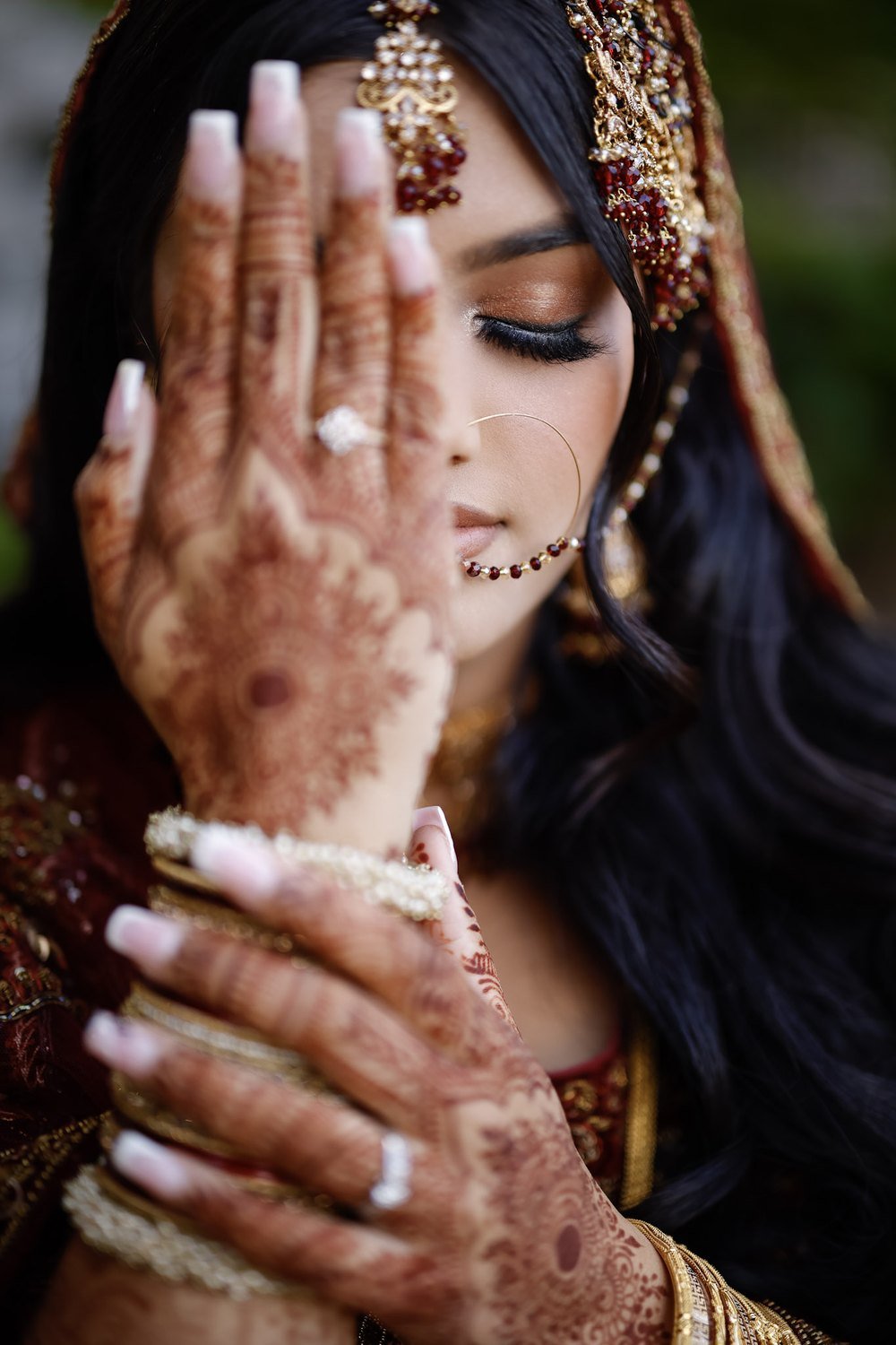 Bride with henna-adorned hands and gold jewellery