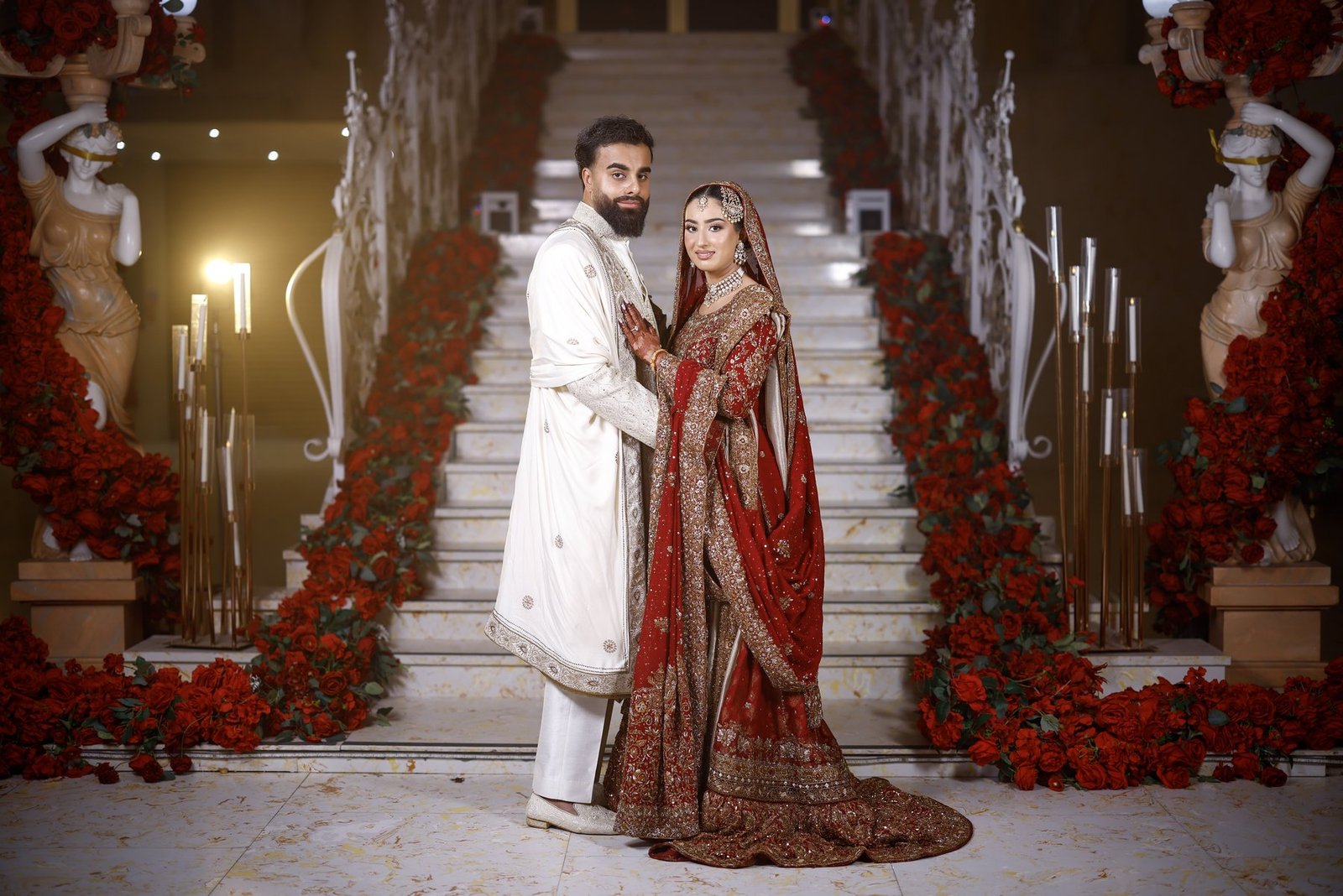 Bride and groom on the red-rose staircase at The Excellency